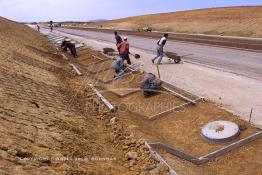 Image du Maroc Professionnelle de  Les ouvriers préparent le sol pour l’installation de risbermes sur une partie du tronçon de l'autoroute Sidi El Yamani Asilah. Lundi 1er Juillet 2002. (Photo / Abdeljalil Bounhar) 